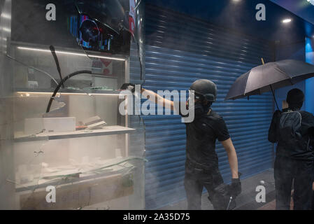 Hongkong, China. 04 Okt, 2019. Die Demonstranten brechen ein Fenster eines China Mobile Store während einer Rallye nach der Regierung aufgerufen Notfall Befugnisse Masken auf Demonstrationen in einer direkten Haltung gegen Demonstranten in Hongkong zu verbieten. Credit: SOPA Images Limited/Alamy leben Nachrichten Stockfoto