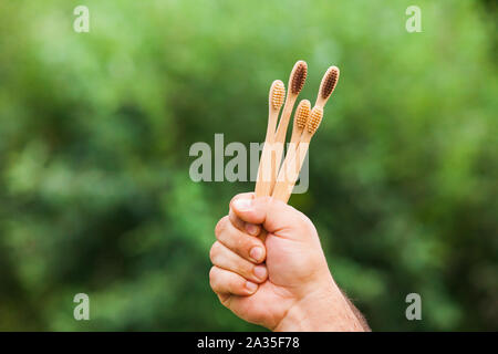 Hand mit Bambus Zahnbürsten auf die Natur im Freien Stockfoto