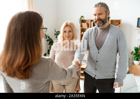 Reifen casual Paar Gruß Ihre Immobilien Berater im Büro Stockfoto