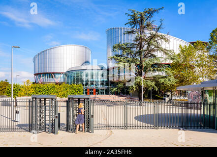 Eine Frau im blauen Kleid, das Drehkreuz der Gebäude des Europäischen Gerichtshofs für Menschenrechte in Straßburg, Frankreich. Stockfoto