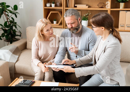 Junge elegante Hündin agent Consulting reifer Mann und Frau im Büro Stockfoto