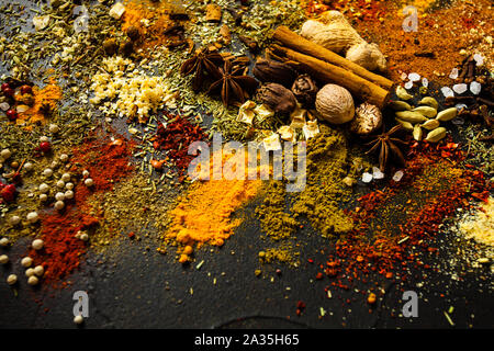 Helle Gewürze Gewürze und Kräuter auf dem Tisch verstreut Stockfoto