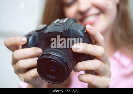 Lächelnd kaukasische Frau photgrapher Holding eine Digitalkamera in den Händen, die ein Foto oder Video. Stockfoto