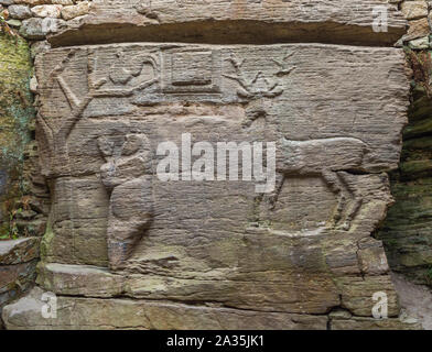 Alte Relief mit der Darstellung eines Heiligen Rehe und eine schwangere Frau zu beten, um den Baum des Lebens auf der Steinplatte in heidnischen Höhlentempel. Stockfoto