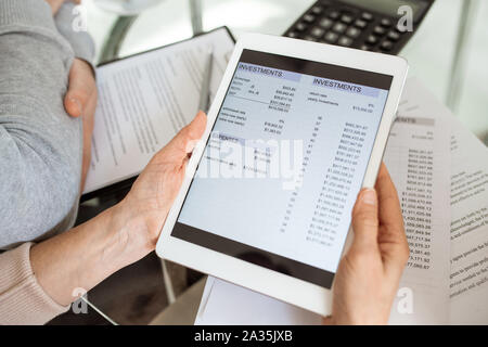 Hände von Reifen Buchhalter holding Touchpad mit elektronischen finanzielle Dokument Stockfoto