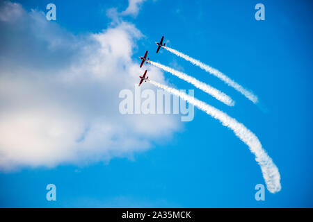 Kunstflug, Air Show. Flugzeuge Team in den Himmel mit alten Flugzeugen und zeichnen Linien, weißen Wolken und blauer Himmel Stockfoto
