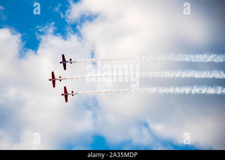 Kunstflug, Air Show. Flugzeuge Team in den Himmel mit alten Flugzeugen und zeichnen Linien, weißen Wolken und blauer Himmel Stockfoto