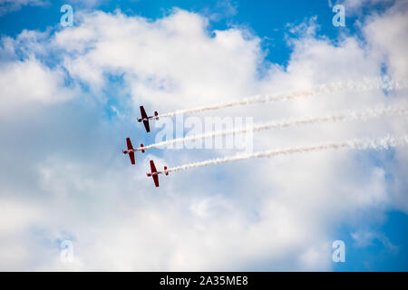 Kunstflug, Air Show. Flugzeuge Team in den Himmel mit alten Flugzeugen und zeichnen Linien, weißen Wolken und blauer Himmel Stockfoto