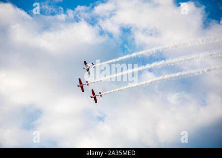 Kunstflug, Air Show. Flugzeuge Team in den Himmel mit alten Flugzeugen und zeichnen Linien, weißen Wolken und blauer Himmel Stockfoto