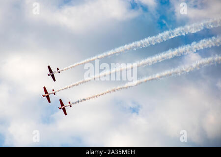Kunstflug, Air Show. Flugzeuge Team in den Himmel mit alten Flugzeugen und zeichnen Linien, weißen Wolken und blauer Himmel Stockfoto