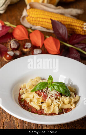 Nudeln mit Tomatensoße auf dunklem Holz Stockfoto