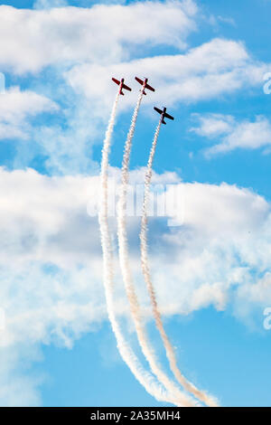 Kunstflug, Air Show. Flugzeuge Team in den Himmel mit alten Flugzeugen und zeichnen Linien, weißen Wolken und blauer Himmel, vertikal Stockfoto