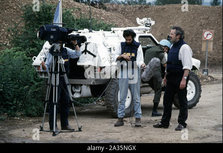 Juni 1993 Während der Belagerung von Sarajevo: Jeremy Bowen (BBC News-Korrespondent) liefert seine Zeilen auf dem Parkplatz am Flughafen Sarajevo neben einem französischen Panhard VBL vor die Kamera. Stockfoto