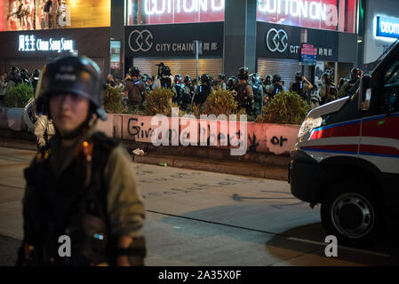 Ein Polizist steht vor einem Polizei van während einer Streuung. Demonstranten nahmen in spontanen Kundgebungen und Demonstrationen in ganz Hongkong als Reaktion auf die jüngsten Anti-mask Gesetz des vorherigen Tages. Demonstrationen und Kundgebungen während des Tages wurden weitgehend ungestört durch die Polizei, obwohl die Polizei mehrere zersteuung Operationen in der Nacht durchgeführt. Stockfoto