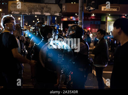 Ein Polizist fragt ein Mann auf dem Bürgersteig. Demonstranten nahmen in spontanen Kundgebungen und Demonstrationen in ganz Hongkong als Reaktion auf die jüngsten Anti-mask Gesetz des vorherigen Tages. Demonstrationen und Kundgebungen während des Tages wurden weitgehend ungestört durch die Polizei, obwohl die Polizei mehrere zersteuung Operationen in der Nacht durchgeführt. Stockfoto