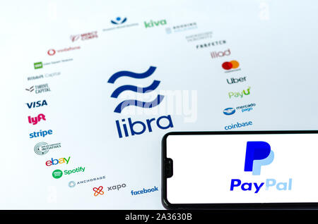 Die Libra Logo auf dem Papier Broschüre und PayPal Logo auf dem Bildschirm des Smartphones. Illustrativ für die News, dass PayPal verlässt den Verein. Stockfoto