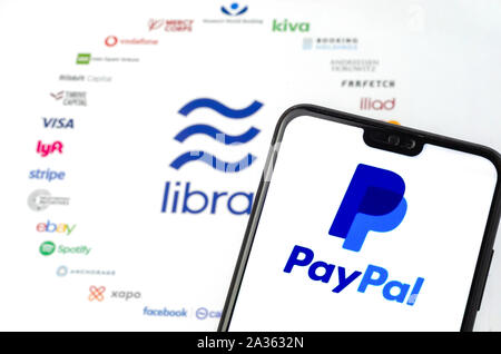 Die Libra Logo auf dem Papier Broschüre und PayPal Logo auf dem Bildschirm des Smartphones. Illustrativ für die News, dass PayPal verlässt den Verein. Stockfoto