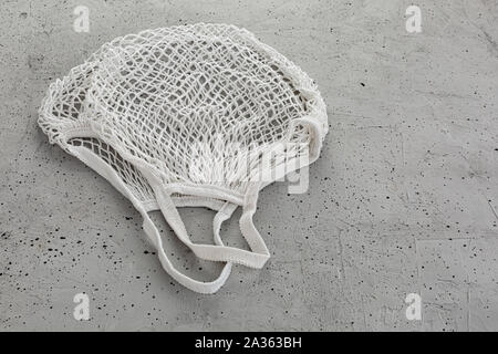 Obst und Gemüse in einem Öko Baumwolle string Beutel auf grauem Hintergrund Stockfoto