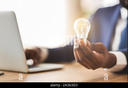 Geschäftsmann Holding leuchtet die Lampe im Büro Stockfoto