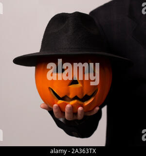 Halloween Kürbis mit schwarzem Hut und lächelndes Gesicht in Hand Stockfoto