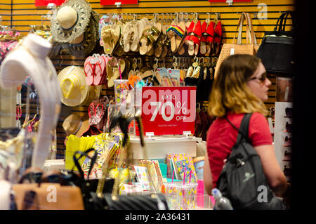 "Bis zu 70% Rabatt "der Verkauf im Shop mit Frau Kleidung und dem Kunden. Foto durch das externe Fenster übernommen. Stockfoto