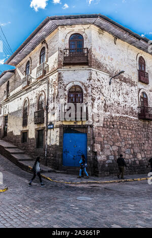 Cusco, Peru - 24.05.2019: Helle blaue Tür und Holz geschnitzten Balkonen im eleganten Zerfall in Cusco, Peru. Stockfoto