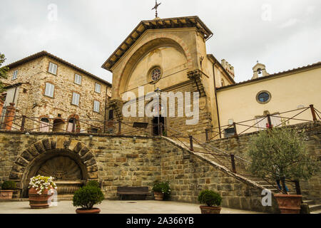 Radda in Chianti, Siena, Toskana/Italien - September 19, 2019: Die alte Kirche Propositura di San Niccolo und der alte Brunnen in der Toskanischen mittelalterlichen Stockfoto