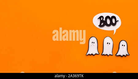 Drei süße Geister versuchen, furchtsam zu sein und Sagen buh auf Orange Stockfoto