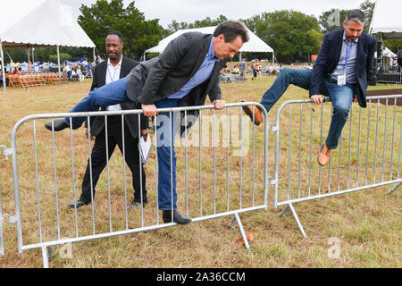 Montana Gouverneur und demokratischen Präsidentschaftskandidaten Steve Farren, rechts, klettert über ein sicherheitszaun an der jährlichen SCDP Blue Jamboree Oktober 5, 2019 in Charleston, South Carolina. Stockfoto