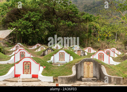 Bang Phra, Thailand - 16. März 2019: Chao Pho Khao Chalak chinesischen Friedhof. Gruppe Familie Gräber mit beige Grabstein mit farbigen Mandarin Buchstaben Stockfoto