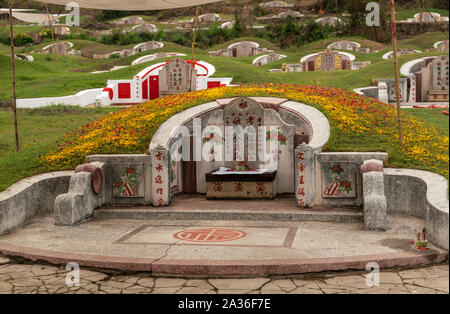 Bang Phra, Thailand - 16. März 2019: Chao Pho Khao Chalak chinesischen Friedhof. Nahaufnahme der Familie Grab mit beige Grabstein und farbigen Mandarin Buchstaben Stockfoto