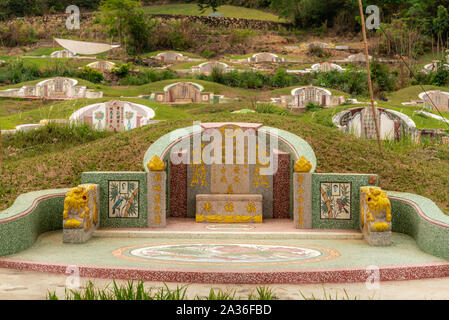 Bang Phra, Thailand - 16. März 2019: Chao Pho Khao Chalak chinesischen Friedhof. Grün-gold Familie Grab mit beige Grabstein und farbigen Mandarin Buchstaben Stockfoto