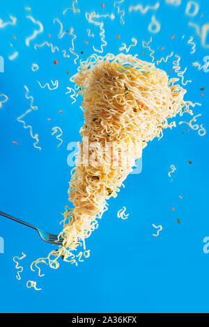 Nudel Tornado mit einer Gabel, instant Ramen in Aktion. Inspiration Konzept mit kreativen Essen Fotografie und Bewegung. Stockfoto