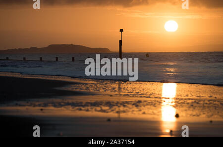 Die Sonne über Boscombe Strand in Dorset. Heavy Rain ist aufgrund einer großen Landstrich der BRITISCHEN zu schlagen, nur wenige Tage, nachdem das Land wurde von großen Überschwemmungen heimgesucht. Stockfoto