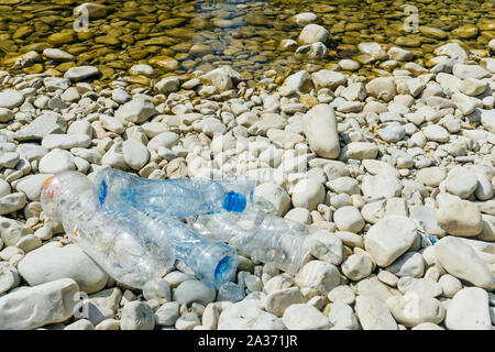 Kunststoff, die Verschmutzung des Flusses. Dirty Plastikflaschen und -tüten auf dem Müll. Die Verschmutzung der Flüsse, Kunststoff in Wasser. Umweltverschmutzung und Recyceln eco-Konzept. Stockfoto