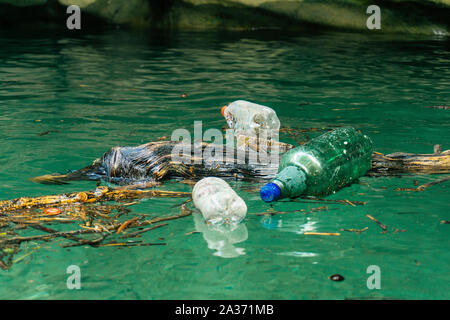 Kunststoff, die Verschmutzung des Flusses. Dirty Plastikflaschen und -tüten auf dem Müll. Die Verschmutzung der Flüsse, Kunststoff in Wasser. Umweltverschmutzung und Recyceln eco-Konzept. Stockfoto