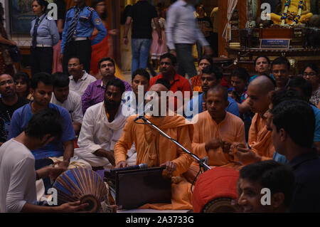 Auf dem indischen Festival von Lord Krishna Geburt Zeremonie (janmastami) Leute tanzen, singen, Genießen, Feiern, Hand in der Nacht bei der iskcon Stockfoto