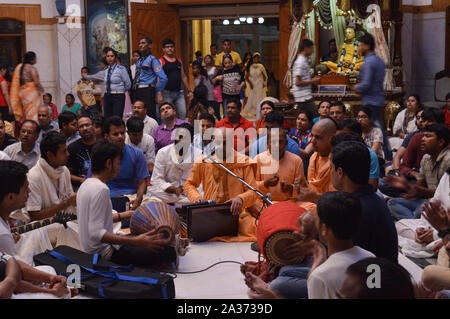 Auf dem indischen Festival von Lord Krishna Geburt Zeremonie (janmastami) Leute tanzen, singen, Genießen, Feiern, Hand in der Nacht bei der iskcon Stockfoto