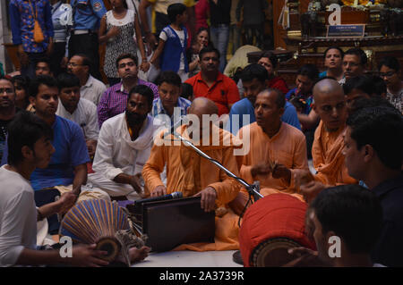 Auf dem indischen Festival von Lord Krishna Geburt Zeremonie (janmastami) Leute tanzen, singen, Genießen, Feiern, Hand in der Nacht bei der iskcon Stockfoto