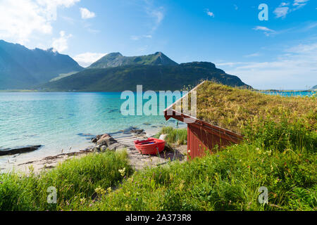 Rot Ruderboot an einem schönen blauen Fjord auf den Lofoten in Norwegen Stockfoto