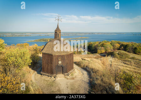 Antenne Landschaft mit einem kleinen hölzernen Kirche auf einem Hügel mit einem herrlichen Blick auf einem Fluss im Dneper Vitachov (Vytachov), Ukraine. Man Tagesausflüge rund um K Stockfoto