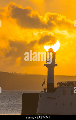 Penzance, Cornwall, UK. 6. Oktober 2019. UK Wetter. Die Sonne geht hinter dem Leuchtturm am Hafen von Penzance. Kredit Simon Maycock/Alamy Leben Nachrichten. Stockfoto