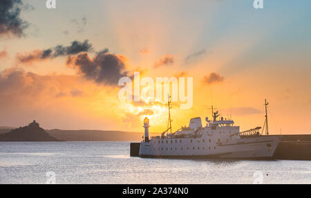 Penzance, Cornwall, UK. 6. Oktober 2019. UK Wetter. Die Sonne geht hinter dem Leuchtturm und die scillonian Fähre am Hafen von Penzance. Kredit Simon Maycock/Alamy Leben Nachrichten. Stockfoto