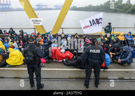 DEUTSCHLAND, Hamburg , Kohleausstieg, Ende der fossilen Brennstoffe, Aktivisten der deCOALonize europe blockieren die Kattwyk-Brücke in der Nähe des Kohlekraftwerks Moorburg, um gegen die Kohleverbrennung und Steinkohleeinfuhren aus Kolumbien und Russland zu protestieren, Banner mit dem Kohlebergbaugebiet Kuzbass in Russland Stockfoto