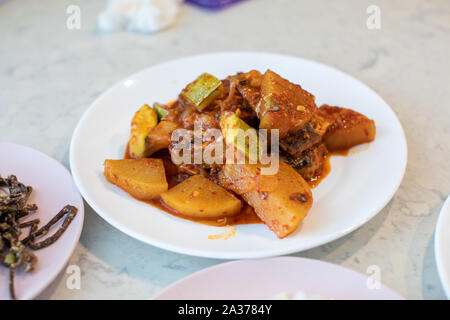 Makrele Eintopf mit würzigen koreanischen Sauce, Kimchi und Radieschen auf einem weißen Teller Stockfoto