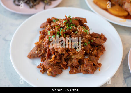 Gebratenes Schweinefleisch (Bulgogi) mit würzigen koreanischen Sauce auf einer Platte Stockfoto
