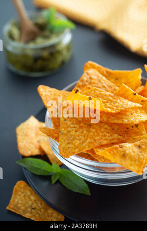 Nachos Chips oder Mais mexikanische Chips in Glasschale, isolierten gesunden Snack für dunklen Hintergrund Stockfoto