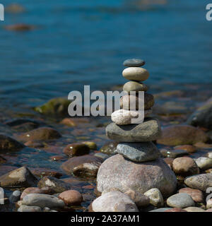 Pyramide der Steine am Abend. Am Ufer des Meeres eine Pyramide aus Steinen. Traum am Strand Stockfoto