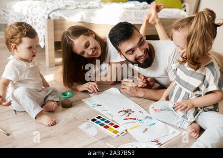 Glückliche Eltern und ihre Kinder ladorable Handabdrücke, bis Foto schliessen. kunst Lektion Stockfoto