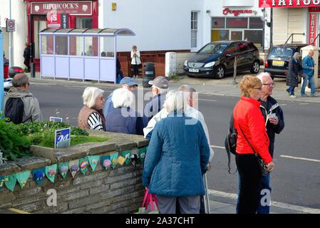 Eine Gruppe von älteren Menschen warten auf einen Bus auf der Strandpromenade in Worthing West Sussex England Großbritannien Stockfoto